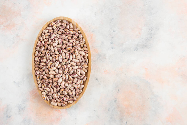 Horní pohled na hromadu fazolí v dřevěném talíři. Kvalitní fotografie - Fotografie, Obrázek