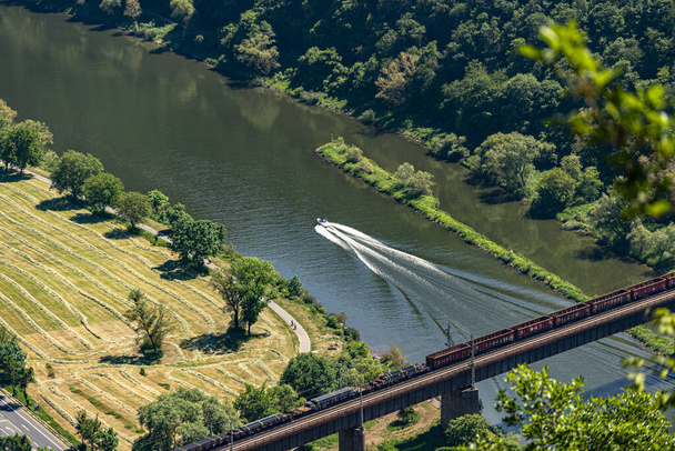Die Stahlfachwerkkonstruktion der Eisenbahnbrücke von oben gesehen, im Hintergrund sind bewaldete Hügel. - Foto, Bild