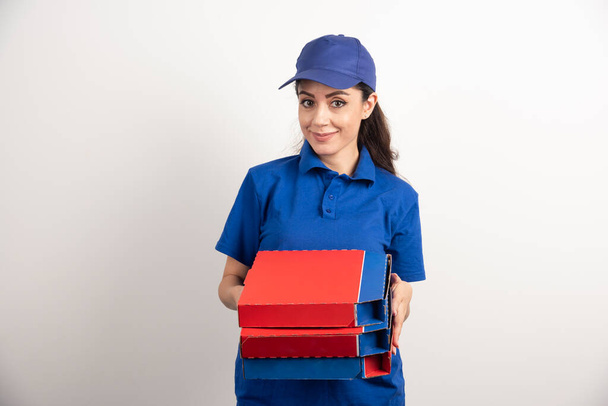Mensajera joven con cartón de pizza y portapapeles  - Foto, imagen