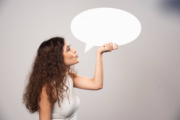Young woman looking at blank white speech bubble. High quality photo - 写真・画像