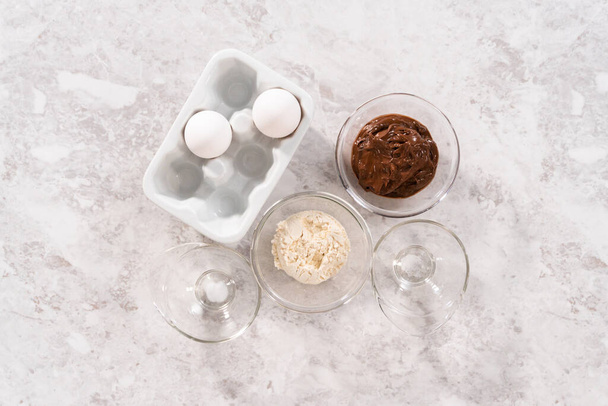 Flat lay. Ingredients in glass mixing bowls to prepare chocolate mug cakes. - Fotoğraf, Görsel