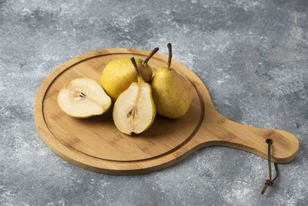 Yellow pears on a wooden platter. High quality photo - Φωτογραφία, εικόνα