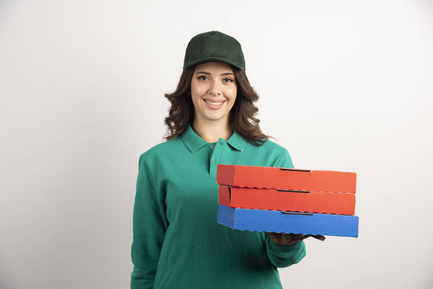 Livraison femme avec boîtes à pizza posant sur fond blanc. Photo de haute qualité - Photo, image