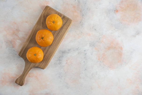 Frische Clementine-Mandarinen in einer Reihe über Holzbrettern. Hochwertiges Foto - Foto, Bild