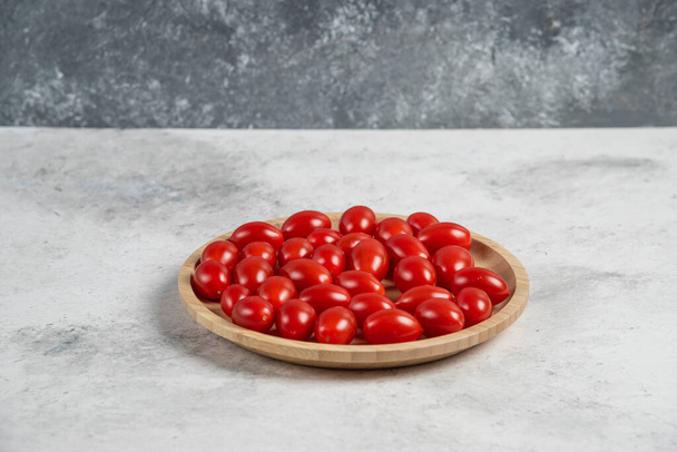 Bunch of fresh tomatoes on wooden plate. High quality photo - Valokuva, kuva