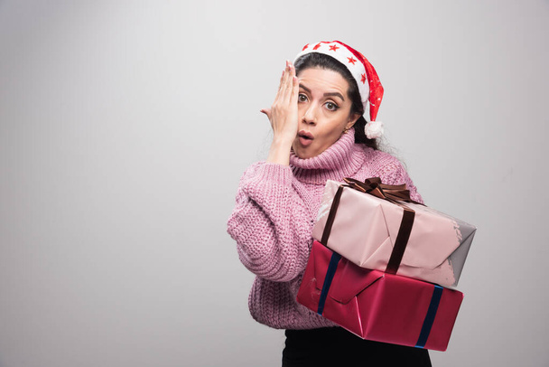 Joven chica de Navidad impactada sosteniendo regalos. Foto de alta calidad - Foto, Imagen