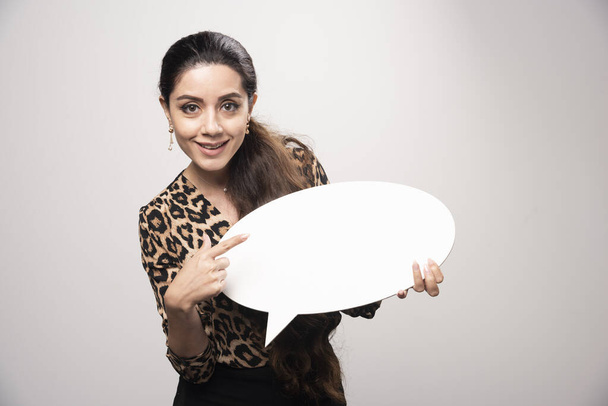 Mulher de negócios em leopardo impresso camisa segurando um thinkboard rodada. Foto de alta qualidade - Foto, Imagem