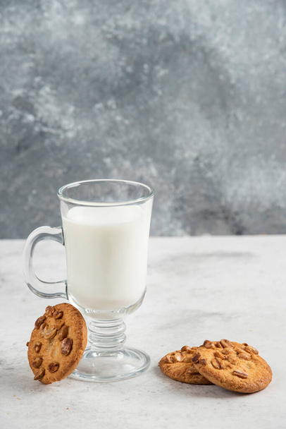 Glass of fresh milk and tasty biscuits on marble background. High quality photo - Photo, Image