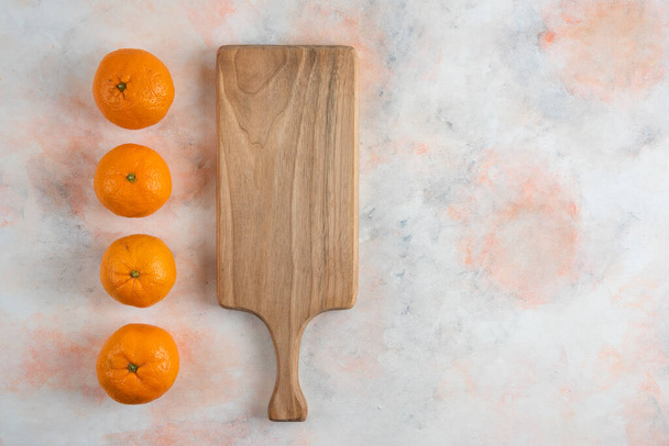 Fresh clementine mandarins in a row behind of wooden board. High quality photo - 写真・画像