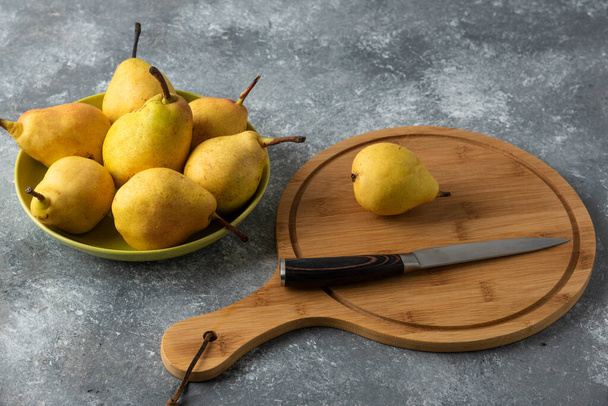 Yellow pears in the stock on concrete background with a wooden board aside. High quality photo - 写真・画像