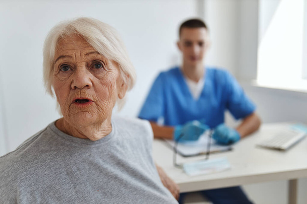 Hastanedeki duygusal yaşlı kadın doktor iletişim tedavisi görüyor. - Fotoğraf, Görsel
