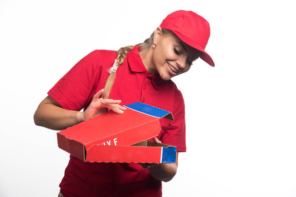 Positive delivery woman opening pizza boxes on white background. High quality photo - Photo, Image