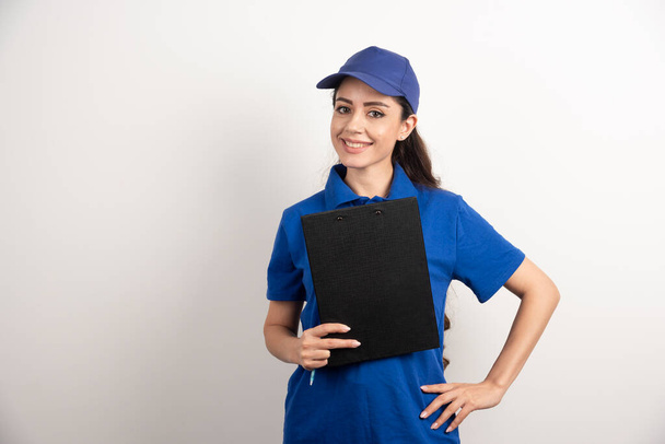 A portrait of a delivery young woman with clipboard . High quality photo - Photo, Image