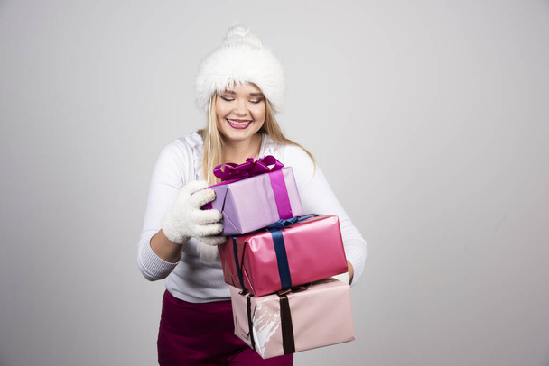 Gyönyörű nő, aki karácsonyi ajándékokat néz. Kiváló minőségű fénykép - Fotó, kép