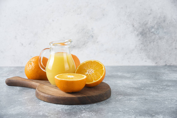 A wooden board full of juicy slices of orange fruit on stone background . High quality photo - 写真・画像