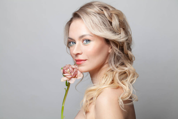 Beautiful young woman with clean fresh skin touch her face flower. Facial treatment. Cosmetology, beauty and spa - Photo, Image