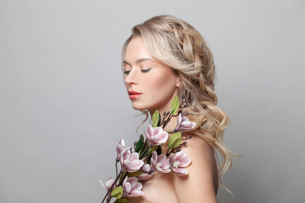Gesunde Frau Modell mit sauberer Haut, leicht nude Make-up, geschlossenen Augen und lockige blonde Frisur Hintergrund - Foto, Bild