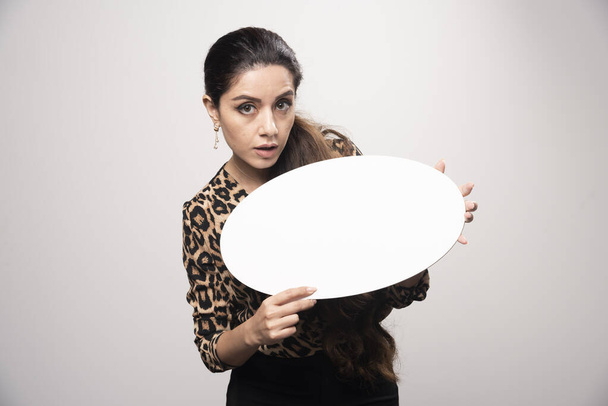 Mulher de negócios em leopardo impresso camisa segurando um thinkboard rodada. Foto de alta qualidade - Foto, Imagem