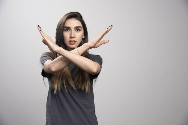 Ciddi bir kadın bir şey yapmamak için kollarıyla X işareti yaptırıyor. Yüksek kalite fotoğraf - Fotoğraf, Görsel