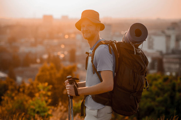 バックパックを持ってハイキングに行く若い男とマット - 写真・画像