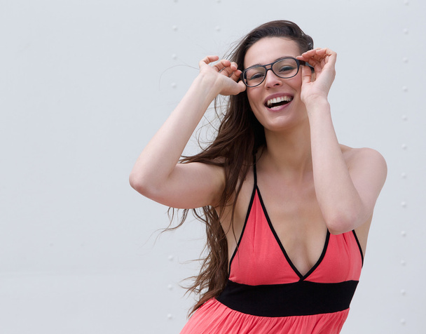 Fiatal nő mosolyog, és a gazdaság szemüveg - Fotó, kép