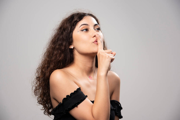 Young woman posing in black blouse with curly hair . High quality photo - 写真・画像