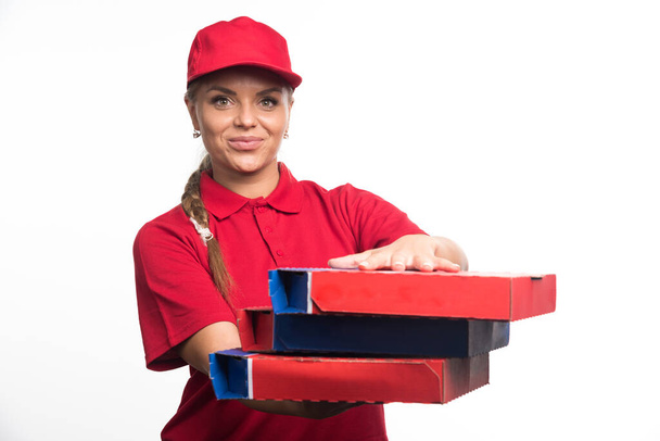 Bella donna consegna che tiene scatole di pizza su sfondo bianco. Foto di alta qualità - Foto, immagini