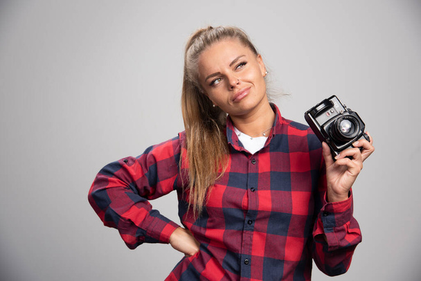 Blonde model in checked shirt looks positive and glamour while taking photos. High quality photo - Photo, Image