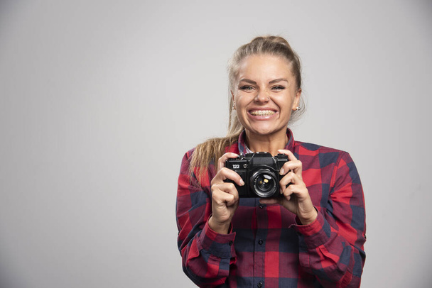 Blonde photograph in checked shirt taking photos and feels positive. High quality photo - Photo, Image