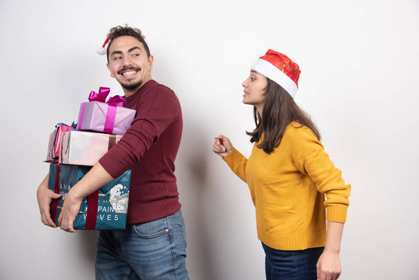 Man and woman carrying a lot of Christmas presents. High quality photo - Foto, Imagen