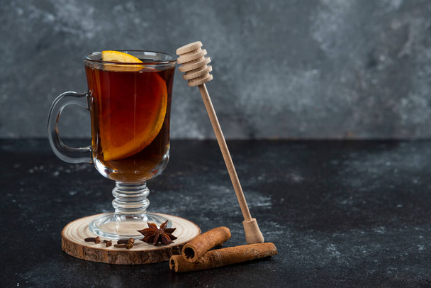 Een glazen kopje thee en met kaneelstokjes en houten dipper. Hoge kwaliteit foto - Foto, afbeelding