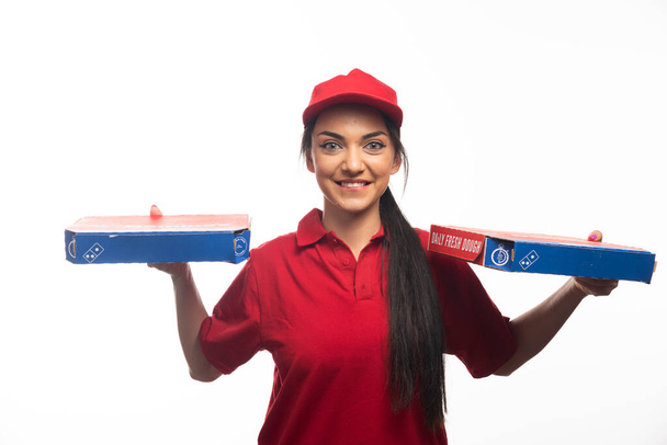 Dostawczyni niosąca kartony z pizzą. Wysokiej jakości zdjęcie - Zdjęcie, obraz