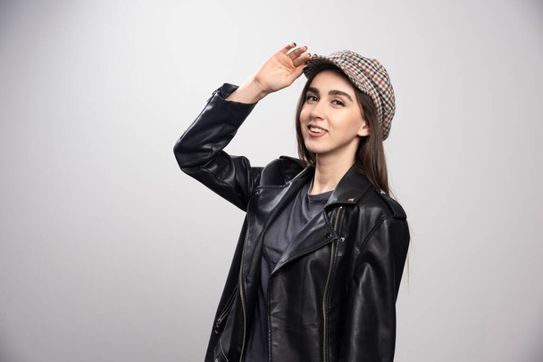 黒い革のジャケットとキャップを身に着けている若い女性。高品質の写真 - 写真・画像