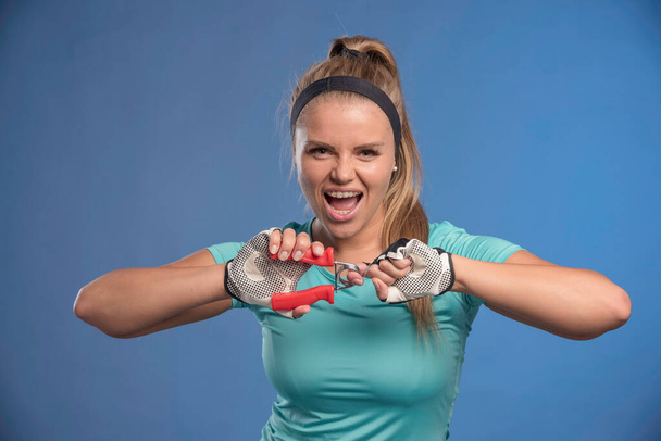 Young sportive woman holding a hand stretching gum and looks strong. High quality photo - Foto, afbeelding