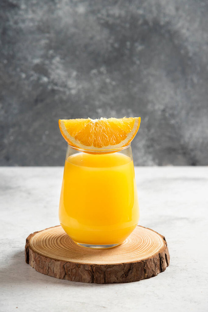 A glass cup of fresh orange juice on a wooden board. High quality photo - Foto, Imagem
