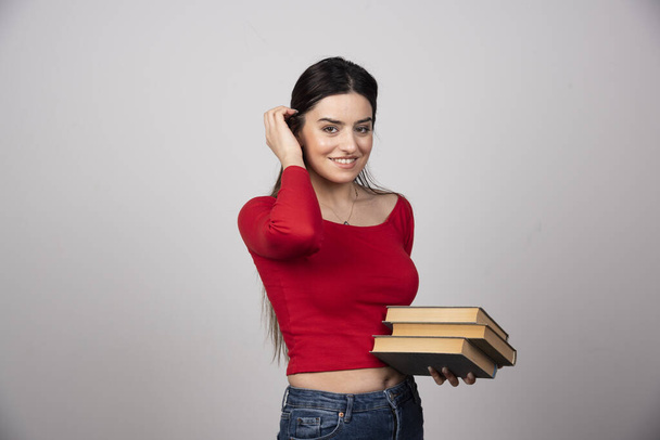 Портрет милой юной брюнетки с книгами. Высокое качество фото - Фото, изображение