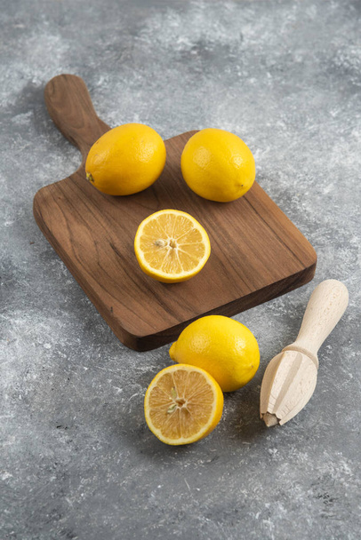Vertical photo of fresh lemons on wooden board. High quality photo - Photo, Image