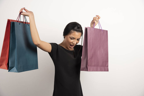 Όμορφη γυναίκα με τσάντες για ψώνια που νιώθει ευτυχισμένη. Υψηλής ποιότητας φωτογραφία - Φωτογραφία, εικόνα