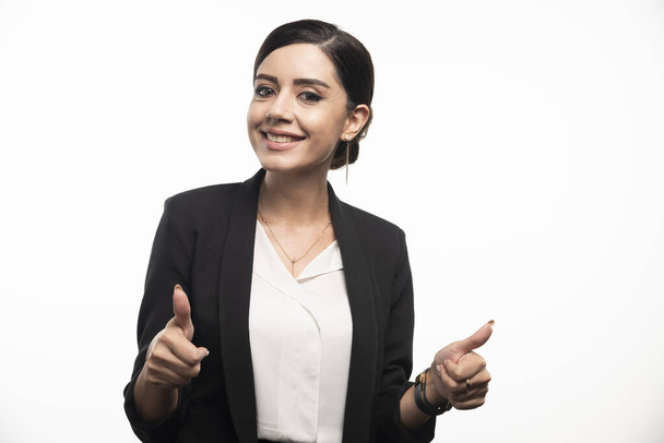 Portrait of smiling young businesswoman showing thumbs up . High quality photo - Foto, Imagem