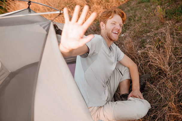 A ginger man looking joyful and stretching his hand - Foto, Imagen