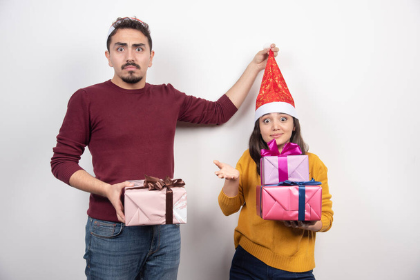 Νεαρός με γυναίκα που ποζάρει με χριστουγεννιάτικα δώρα. Υψηλής ποιότητας φωτογραφία - Φωτογραφία, εικόνα