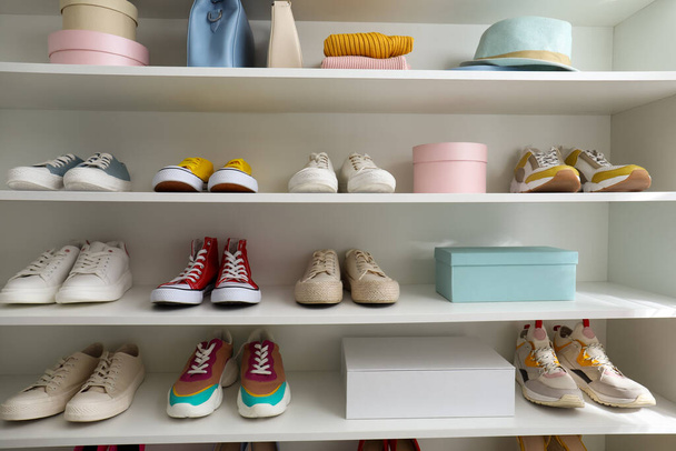 White shelving unit with collection of colorful sneakers and accessories - Foto, Bild