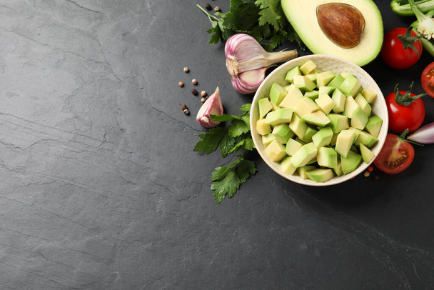 Fresh guacamole ingredients on black table, flat lay. Space for text - Foto, immagini