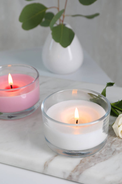 Burning candles in glass holders on white table - Photo, Image