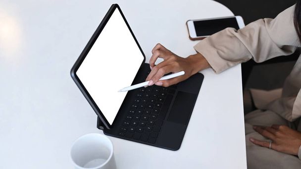 Крупный план женщины-дизайнера, держащей перо стилуса на экране планшетного компьютера. - Фото, изображение
