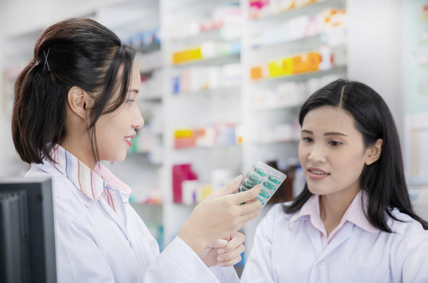 Портрет двух счастливых дружелюбных фармацевтов, работающих в современной аптеке - Фото, изображение