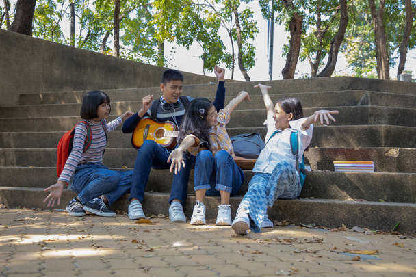 Группа азиатских подростков наслаждаются вместе в парке в солнечный день - Фото, изображение