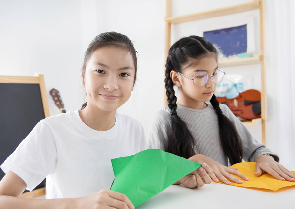 Két ázsiai gyerekek tanulás összecsukható papír művészet origami idő, gyermek elképzelni és fejlődni - Fotó, kép