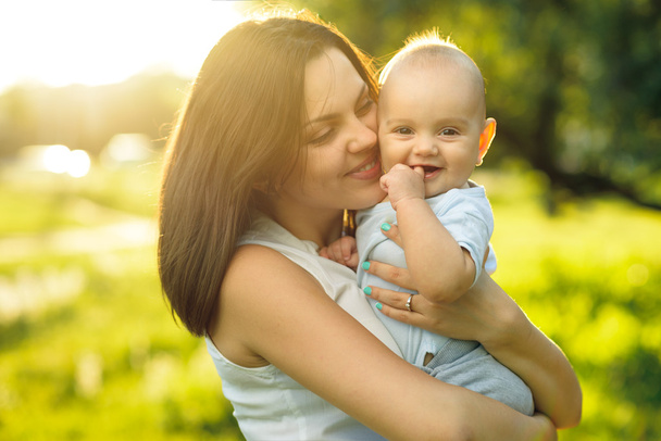 Happy mother holding a young son sunlight - Foto, Imagen