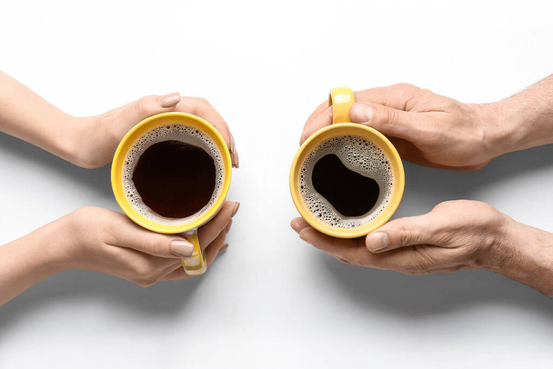 Woman and man with cups of coffee on white background - Fotoğraf, Görsel